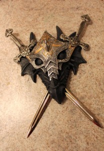 Not that this is from Skyrim, but now that he's Dragonborn, he's even more into dragons than he was just being a fantasy, D&D dork. This is spiffy, though - the swords can be taken out. I hung it near the office, so I use them for letter openers. ::chortle::